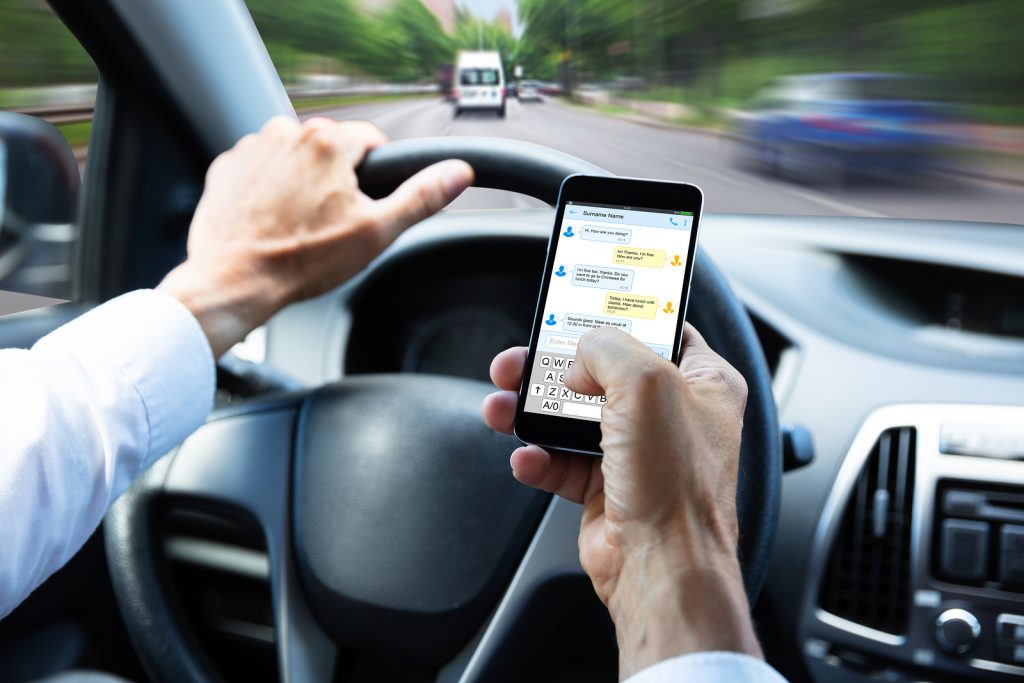 Man Texting while Driving in Florida - Florida New Texting Driving Law - The Eberst Law Firm