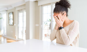Woman crying at her kitchen counter