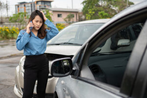 Confused woman talking on the phone after a car accident