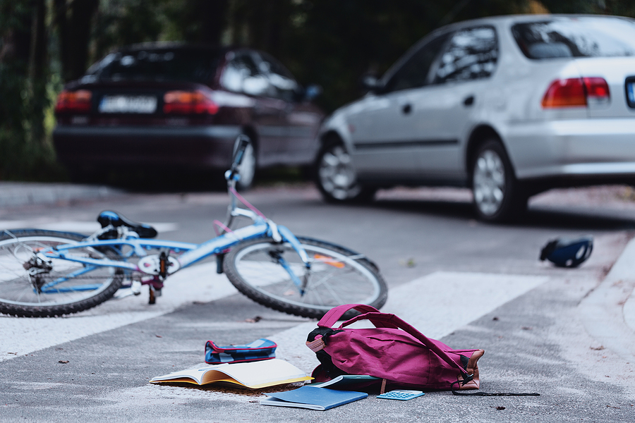 Damaged bicycle lays in the middle of the street after a collision with a car