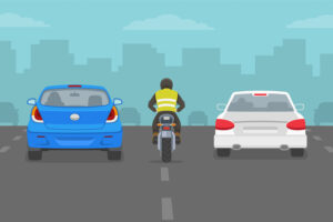 Motorcycle rider between cars